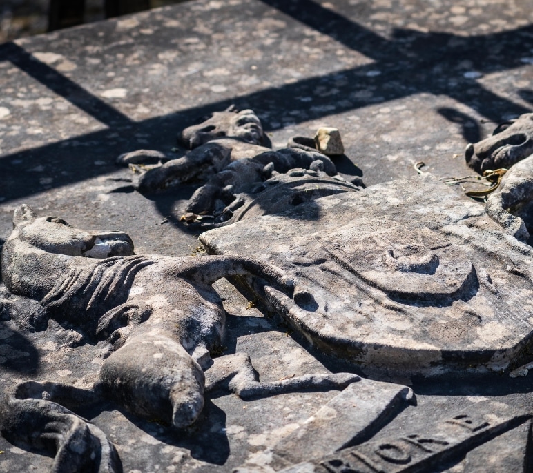 Stone carvings of horse and shield on a tomb